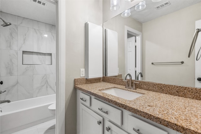 full bathroom with vanity, toilet, and tiled shower / bath combo