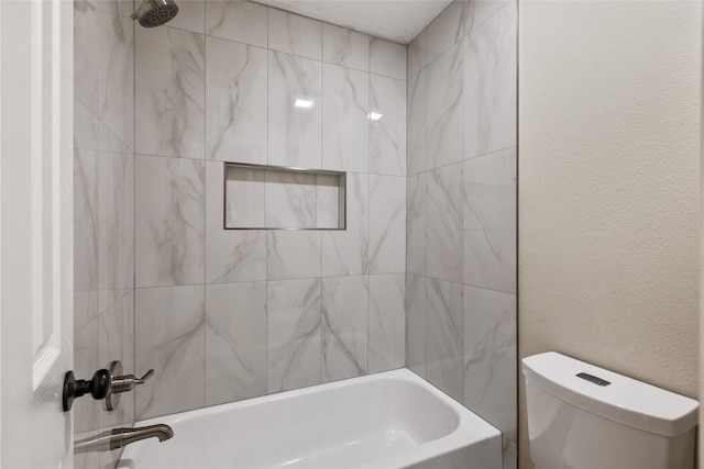 bathroom with tiled shower / bath and toilet