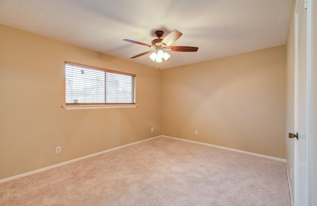 carpeted spare room with a textured ceiling and ceiling fan