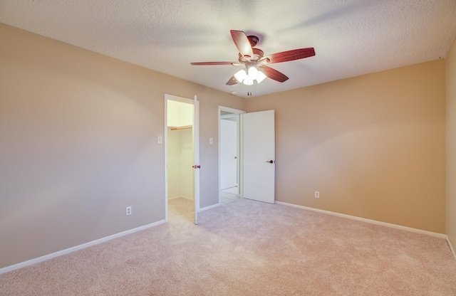 carpeted spare room featuring ceiling fan and a textured ceiling