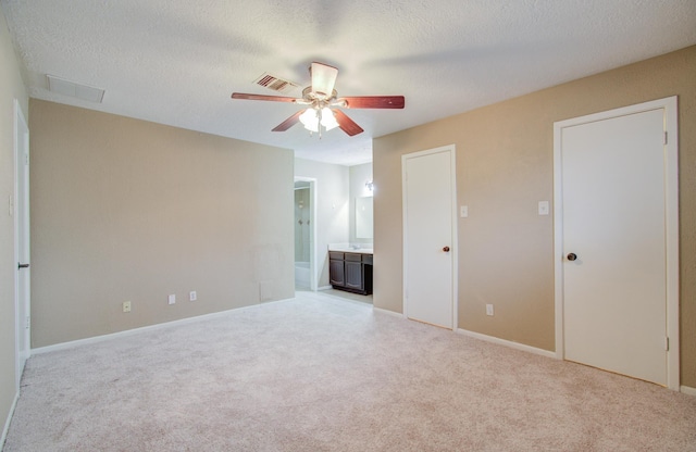 spare room with light carpet, ceiling fan, and a textured ceiling