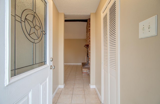 hallway with light tile patterned flooring and a textured ceiling