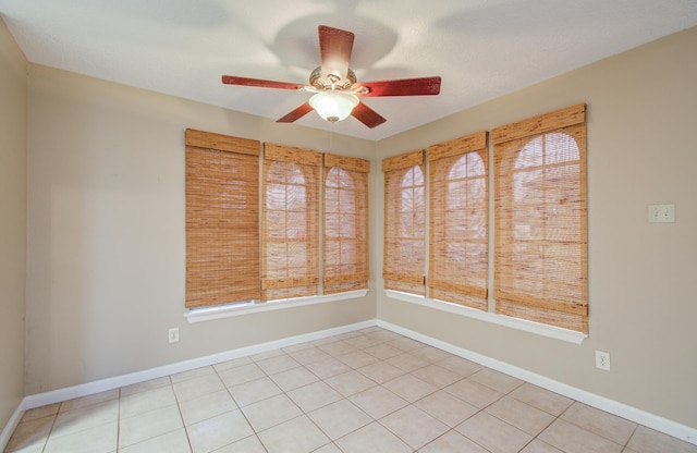 tiled empty room with plenty of natural light and ceiling fan