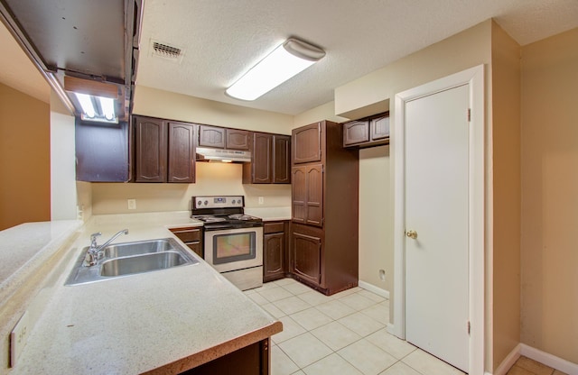 kitchen with electric stove, sink, light tile patterned floors, and dark brown cabinetry