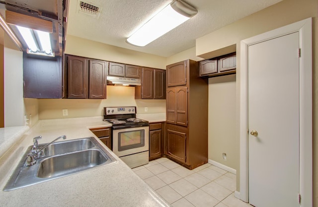 kitchen with light tile patterned flooring, sink, dark brown cabinets, a textured ceiling, and stainless steel electric range