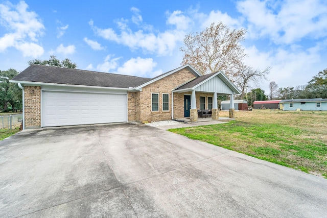 view of front of house featuring a garage, a front lawn, and covered porch