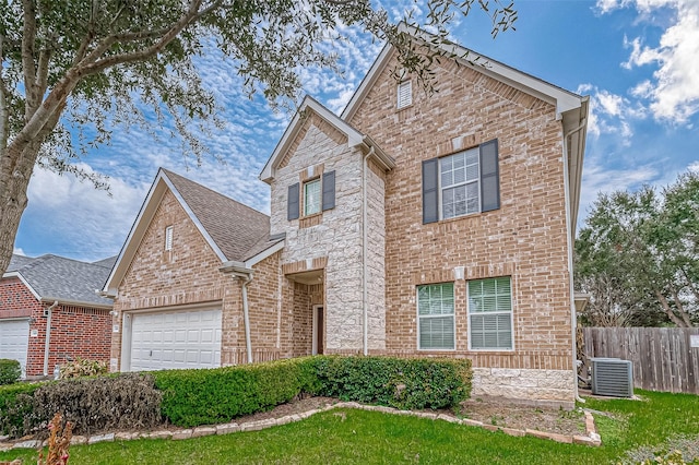 traditional home with an attached garage, central air condition unit, brick siding, fence, and stone siding