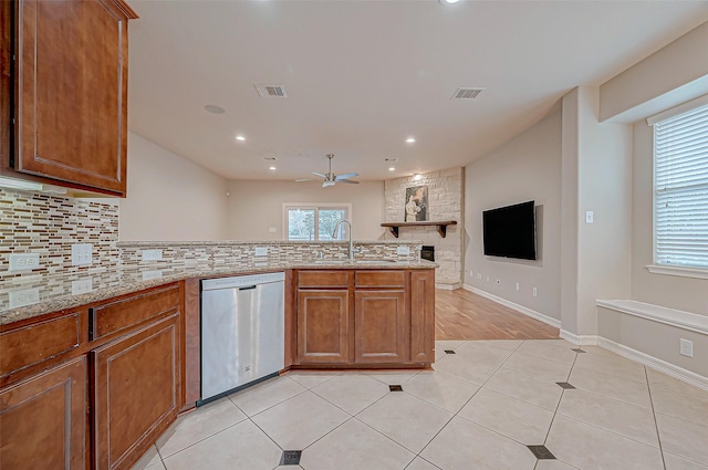 kitchen with light tile patterned flooring, sink, stainless steel dishwasher, and backsplash