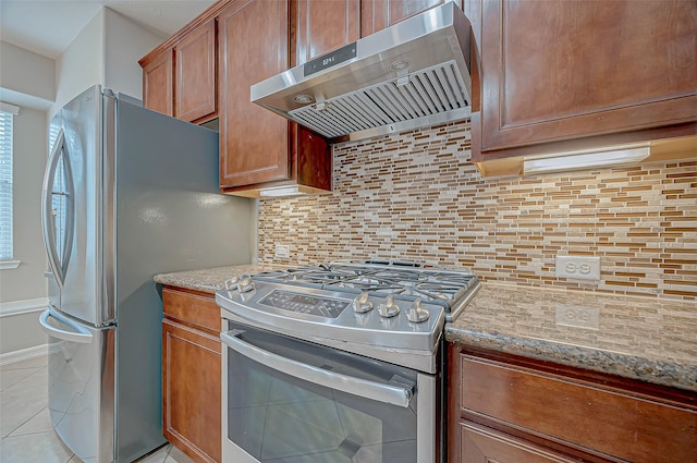 kitchen with light stone counters, light tile patterned floors, stainless steel appliances, backsplash, and extractor fan