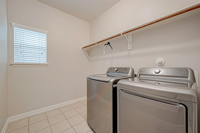 clothes washing area featuring washer and clothes dryer and light tile patterned flooring