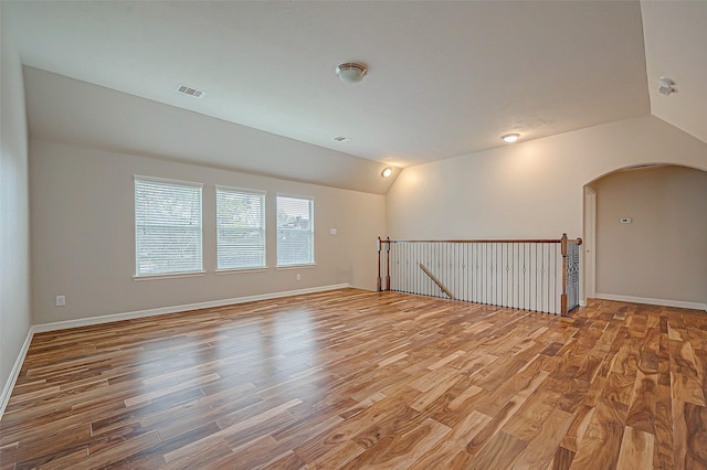 unfurnished room with lofted ceiling and wood-type flooring