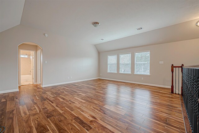 unfurnished living room featuring hardwood / wood-style flooring and vaulted ceiling