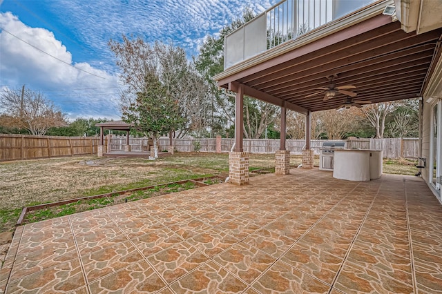 view of patio / terrace with a gazebo, exterior kitchen, a fenced backyard, and a ceiling fan