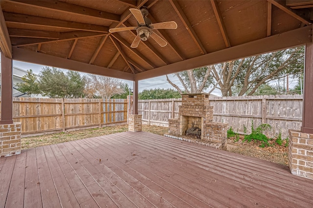 deck featuring a gazebo, ceiling fan, and an outdoor stone fireplace