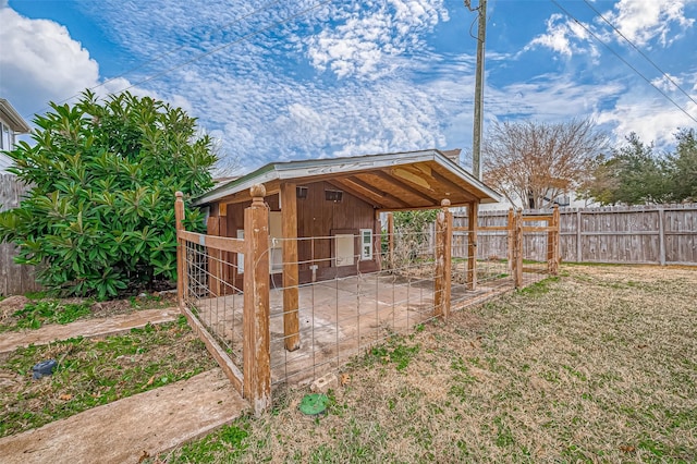 view of outbuilding featuring fence and an outbuilding