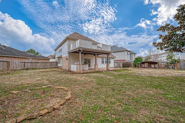 rear view of house featuring a lawn and a balcony