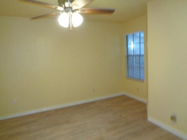 empty room with ceiling fan and light wood-type flooring