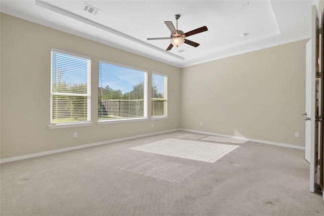 unfurnished room with light carpet, ornamental molding, a raised ceiling, and ceiling fan