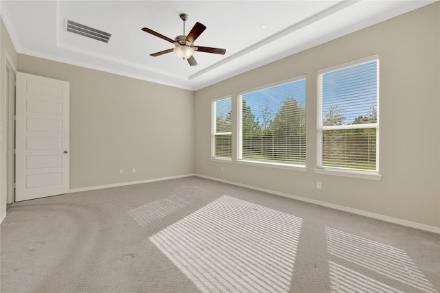 unfurnished room featuring crown molding, light colored carpet, a raised ceiling, and ceiling fan