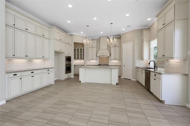 kitchen featuring a kitchen island, hanging light fixtures, light stone counters, stainless steel appliances, and custom range hood