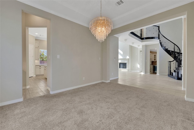 spare room featuring an inviting chandelier, crown molding, and light colored carpet