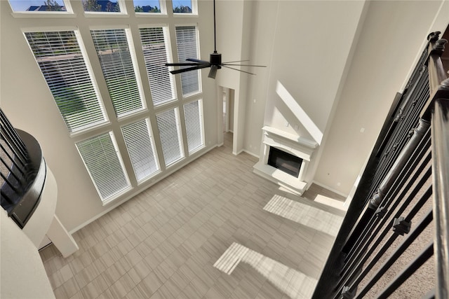 carpeted living room featuring a high ceiling and ceiling fan