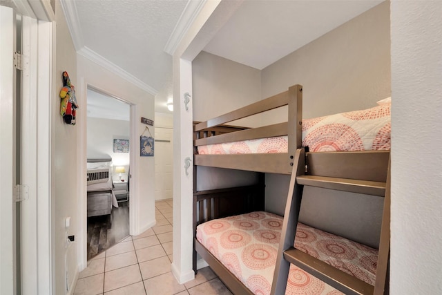 bedroom with light tile patterned floors, crown molding, and a textured ceiling