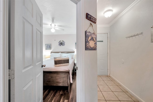 tiled bedroom with ceiling fan, ornamental molding, and a textured ceiling