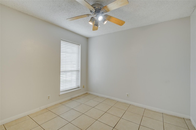 empty room featuring light tile patterned floors, a textured ceiling, plenty of natural light, and ceiling fan