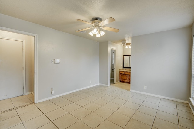 tiled empty room featuring a textured ceiling and ceiling fan