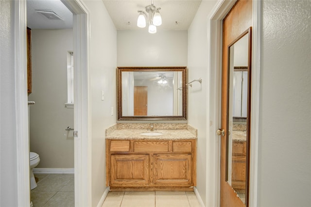 bathroom featuring a chandelier, tile patterned flooring, vanity, toilet, and a textured ceiling