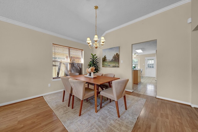 dining space featuring a notable chandelier, ornamental molding, and light hardwood / wood-style floors