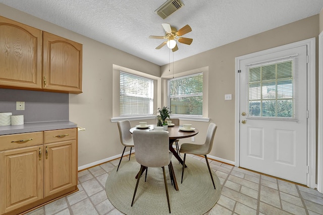 dining room with ceiling fan and a textured ceiling