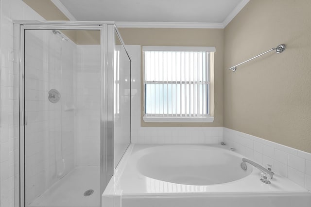 bathroom featuring ornamental molding and shower with separate bathtub