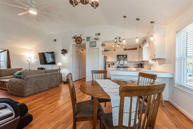 dining space featuring light wood-style floors, lofted ceiling, and plenty of natural light