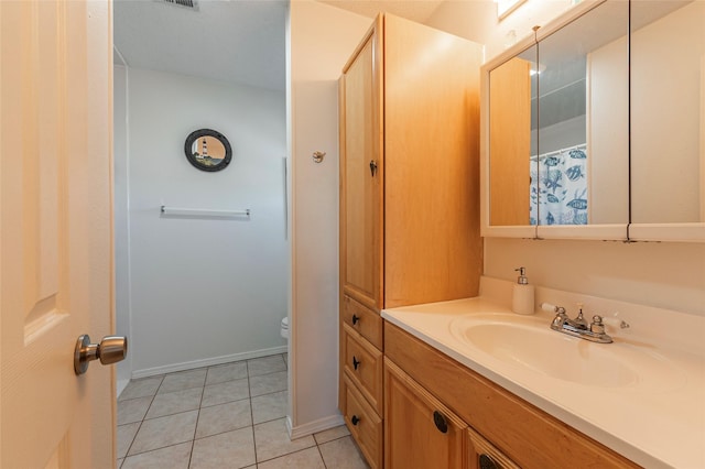 bathroom featuring tile patterned flooring, vanity, and toilet