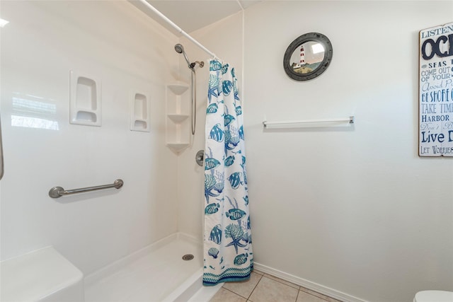 full bath featuring a stall shower, baseboards, and tile patterned floors