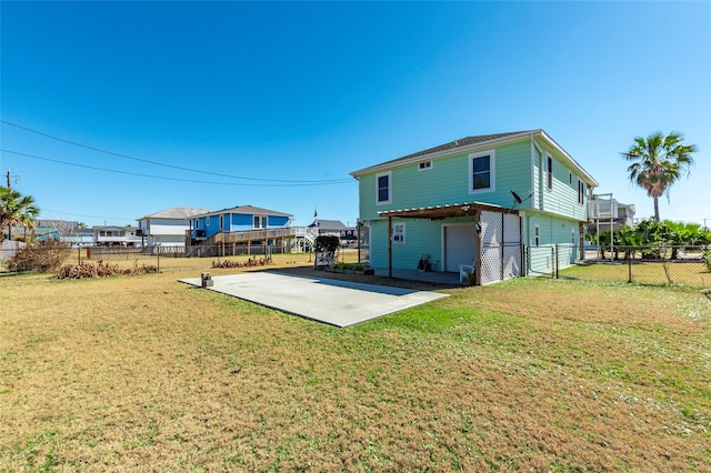 rear view of house with a patio area, fence, concrete driveway, and a yard