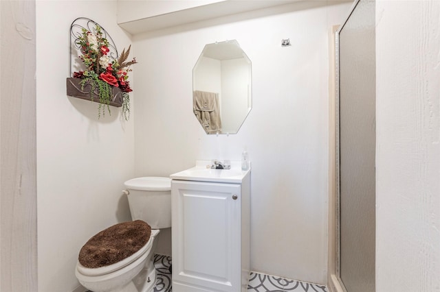 full bath with a stall shower, vanity, and toilet