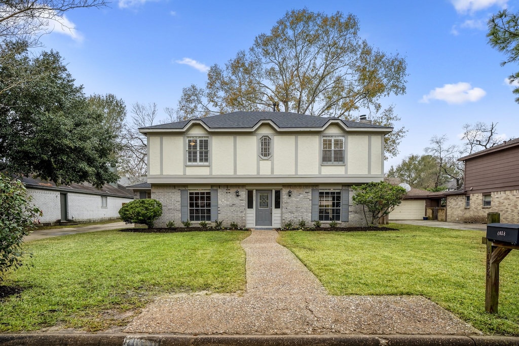 tudor home with a garage and a front yard