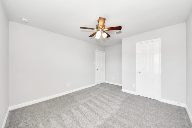 carpeted spare room with ceiling fan