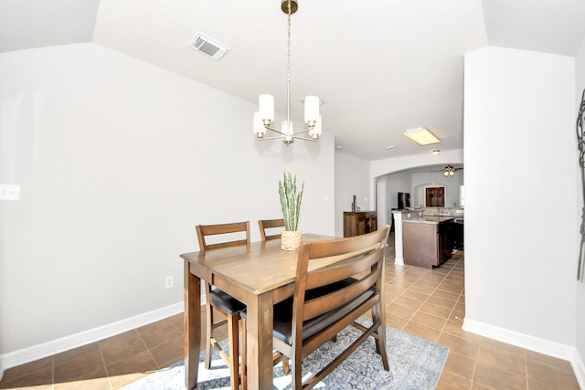 dining space featuring ceiling fan with notable chandelier, lofted ceiling, and light tile patterned floors