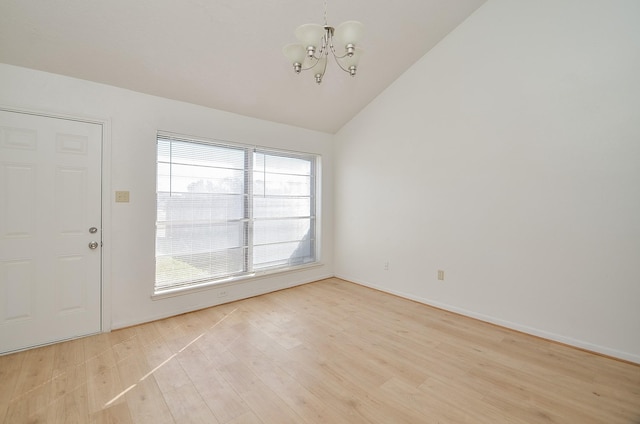 entryway featuring an inviting chandelier, vaulted ceiling, and light hardwood / wood-style floors