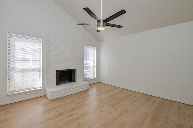 unfurnished living room featuring a fireplace, high vaulted ceiling, ceiling fan, and light wood-type flooring