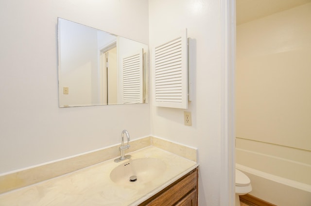 bathroom featuring vanity, toilet, and a washtub