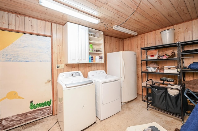 washroom with independent washer and dryer, wooden ceiling, and wooden walls