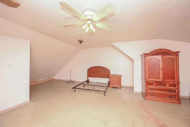 additional living space with ceiling fan, vaulted ceiling, and a textured ceiling