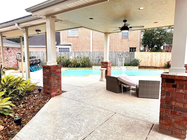 view of swimming pool with ceiling fan and a patio