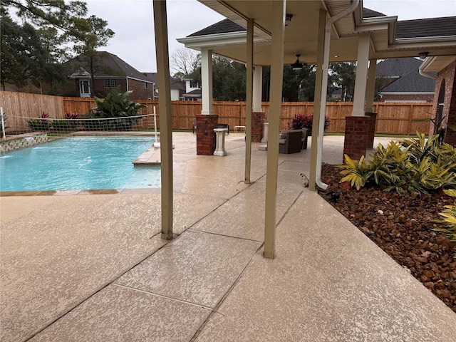 view of swimming pool with pool water feature and a patio