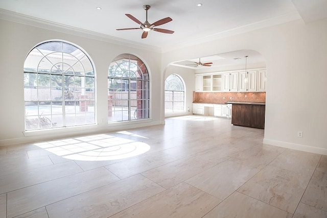 empty room featuring crown molding and ceiling fan